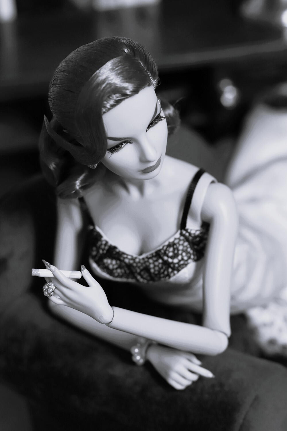 Artistic doll photograph in black and white showing a Agnes von Weiss doll smoking a cigarette in dramatic light, old hollywood glamour vibes.